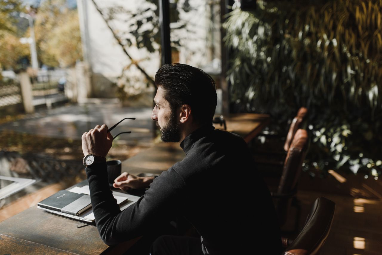 Executive quietly reflecting at a desk, showing signs of high-functioning burnout